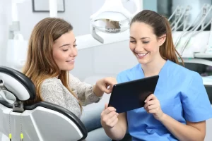 Dentist showing patient her treatment options on ipad