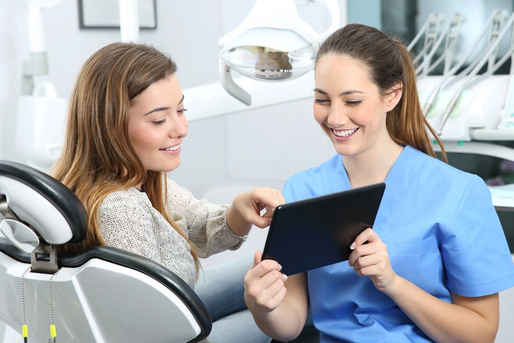 Dentist showing patient her treatment options on ipad